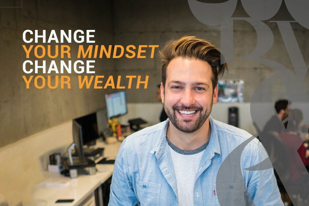 A man standing in his office. He read a blog change your mindset, change your wealth